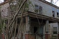 Old creepy scary wooden overgrown abandoned mansion corner view porch windows