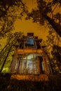 Old creepy wooden abandoned haunted mansion at night