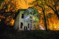 Old creepy wooden abandoned haunted ruined mansion at night Royalty Free Stock Photo