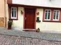 Old crooked tiny house with a wooden door and narrow windows on a paved street Bacharach, Germany Royalty Free Stock Photo