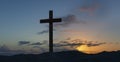 An old cross on sand dune next to the ocean with a calm sunrise Royalty Free Stock Photo