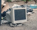 Old CRT monitor in landfill. Recycling of computer components, environmental problems Royalty Free Stock Photo