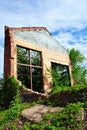 Old crumbling brick wall with window without glass, green trees and blue cloudy sky Royalty Free Stock Photo