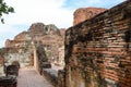 Old crumbling overgrown brick wall in front of stupa at historic park thailand Royalty Free Stock Photo