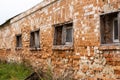 Old crumbling red brick building with small wooden windows Royalty Free Stock Photo