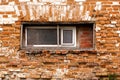 Old crumbling red brick building with small wooden windows Royalty Free Stock Photo