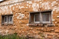 Old crumbling red brick building with small wooden windows Royalty Free Stock Photo