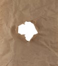Old crumpled recycled paper with a hole in the center on white Royalty Free Stock Photo