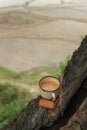 Old cup of milk tea with glucose biscuits on a wooden bark in the fields Royalty Free Stock Photo