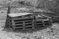 Old curves and broken pallets lie on the grass by the fence.