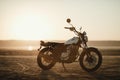 Old custom beautiful cafe racer motorcycle in the desert at sunset or sunrise Royalty Free Stock Photo