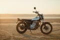 Old custom beautiful cafe racer motorcycle in the desert at sunset or sunrise Royalty Free Stock Photo