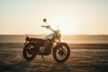 Old custom beautiful cafe racer motorcycle in the desert at sunset or sunrise Royalty Free Stock Photo