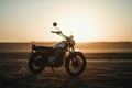 Old custom beautiful cafe racer motorcycle in the desert at sunset or sunrise Royalty Free Stock Photo