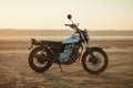 Old custom beautiful cafe racer motorcycle in the desert at sunset or sunrise Royalty Free Stock Photo