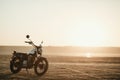 Old custom beautiful cafe racer motorcycle in the desert at sunset or sunrise Royalty Free Stock Photo