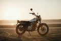 old custom beautiful cafe racer motorcycle in the desert at sunset or sunrise Royalty Free Stock Photo