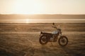 Old custom beautiful cafe racer motorcycle in the desert at sunset or sunrise Royalty Free Stock Photo