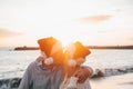 Old cute couple of mature persons enjoying and having fun together at the beach wearing christmas hats on holiday days. Hugged on Royalty Free Stock Photo