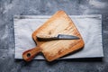 old cutting board with a knife and a napkin ongrey wooden table. View from above. copyspace