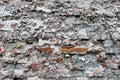 An old damaged brick wall coated with heavily damaged plaster Royalty Free Stock Photo