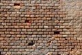 Old damaged brick wall with holes in place of some bricks Royalty Free Stock Photo