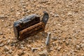 Old, damaged, discarded office chair buried under mud