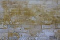 Old damaged gray wall of large bricks with yellow spots of paint. rough surface texture Royalty Free Stock Photo