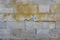 Old damaged gray wall of large stone bricks with yellow spots of paint. rough surface texture Royalty Free Stock Photo