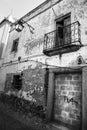 Old damaged house with forged iron balcony and vintage streetlight