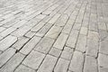 Old and damaged italian paving made with chiseled grey sandstone blocks in a pedestrian zone