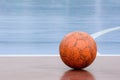 Old and damaged orange ball at futsal court. Royalty Free Stock Photo