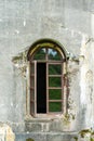 Old damaged plastered brick wall with window