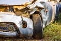 Old damaged rusty car wreck in the grass