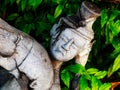 An old damaged sculpture of a man with an angry and unhappy expression on his face