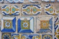 Old damaged tiles with floral ornate painted in Spain. Real textured multi coloured ceramic background. Vivid colours remains.