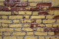 Old damaged white, beige, red brick wall with yellow spots of paint close-up. rough surface texture Royalty Free Stock Photo