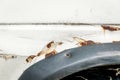 Old damaged white paint color rusty car with corroded metal over the tire Royalty Free Stock Photo