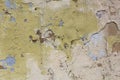 Old damaged white yellow wall with peeling brown and blue paint. rough surface texture Royalty Free Stock Photo