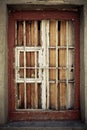 An old damaged window behind metal grating