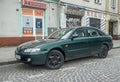 Old classic dark green sedan car Mazda 626 parked