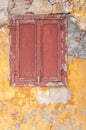 Old dark red wooden window on concrete broken textured house wall Royalty Free Stock Photo