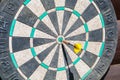 An old dart board with a dart in the center Royalty Free Stock Photo