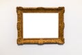 Old decorated wide gold picture frame on gray wall