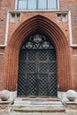 Old decorative wooden entrance door to the church. Large wooden arched gates with carved details, decorative metal Royalty Free Stock Photo