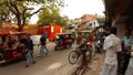 old Delhi busy street auto and cycle rickshaws ancient buildings red fence