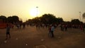 square with numerous people in rays of sunset near red fort old Delhi