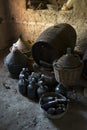 Old demijohns aged wine bottles and wooden barrels in a basement Royalty Free Stock Photo