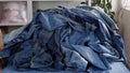 Old denim jeans, textile waste, Denim fabric. Recycling denim clothing. Cotton-based clothing, such as denim, makes up a