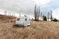 Old derelict caravan sitting abandoned in a rural paddock